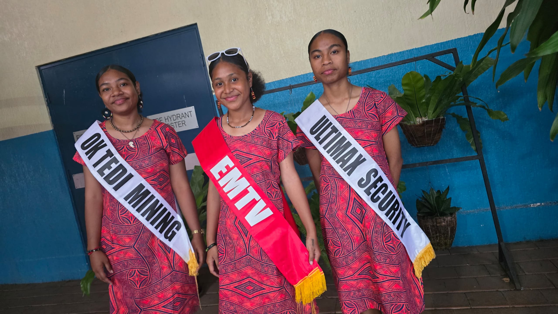 Three sponsor sash bearers in matching meri blouses representing Ok Tedi Mining, EMTV and Ultimax Security