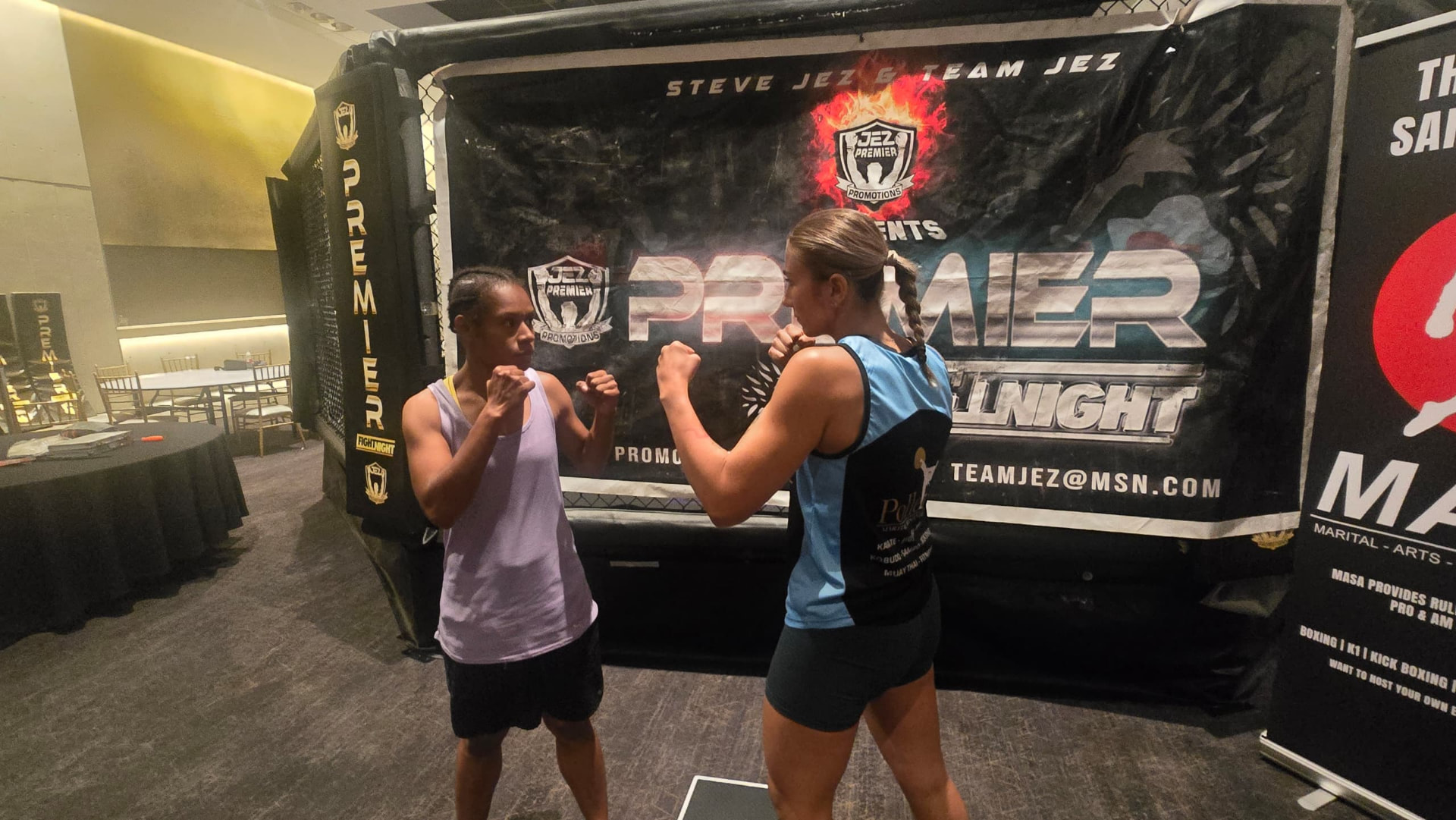 PNG female fighter facing her opponent in a staredown in front of the Premier Fight Night cage