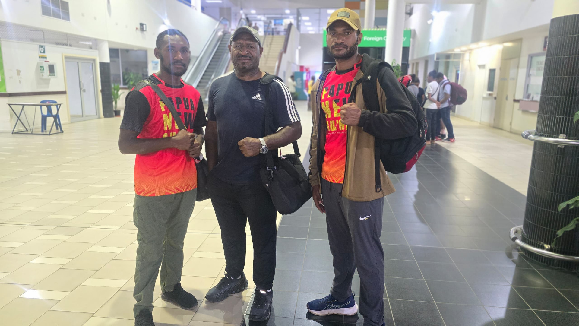 PNG fighters and coach in national jerseys at the airport terminal before departure